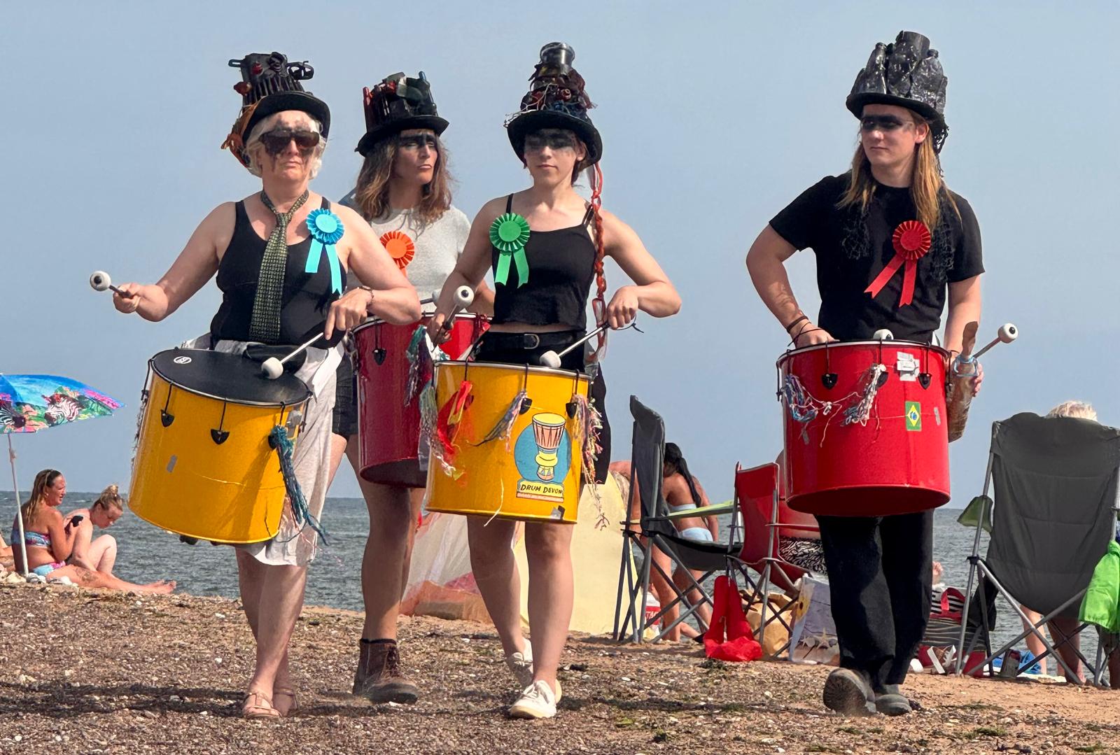 Drummers dressed as hermit crabs on Exmouth beach