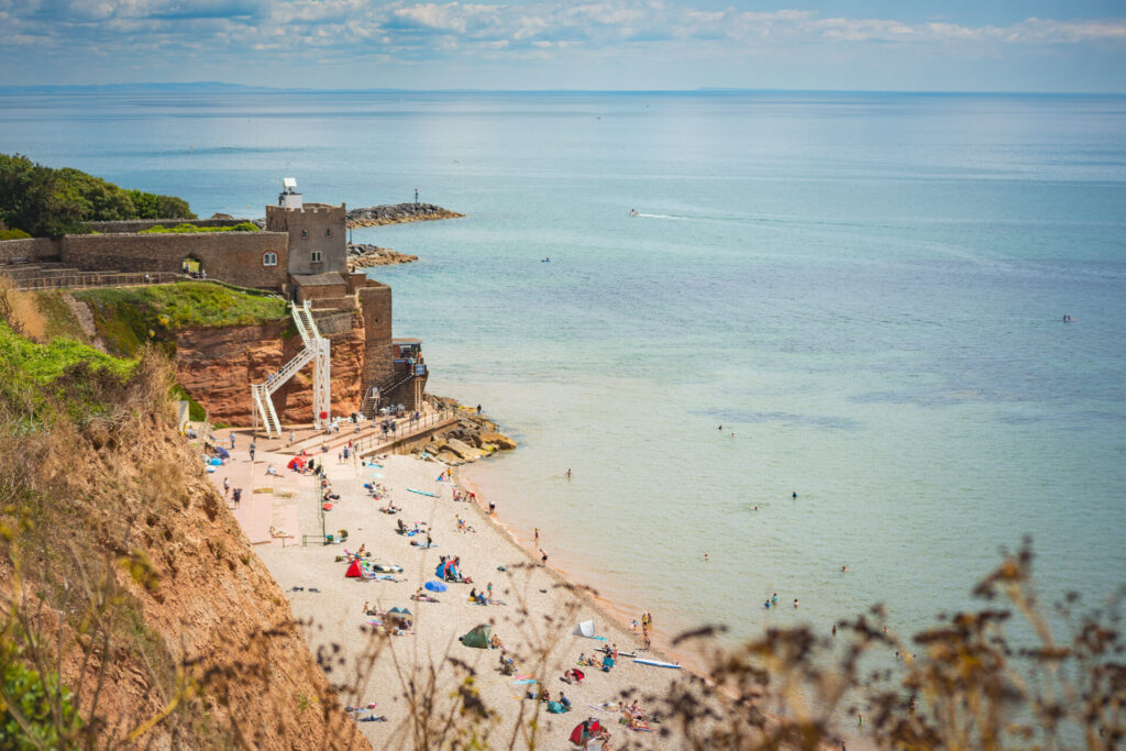 branscombe beach in summer full of people on sunny day